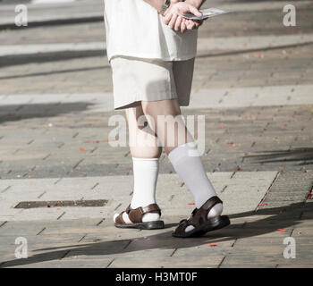 Älterer Mann mit Socken und Sandalen Stockfoto