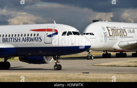 Ein Flugzeug der British Airways und Emirates Airbus A380 vorbereiten für den Start auf der Start-und Landebahn am Flughafen London Heathrow. Stockfoto