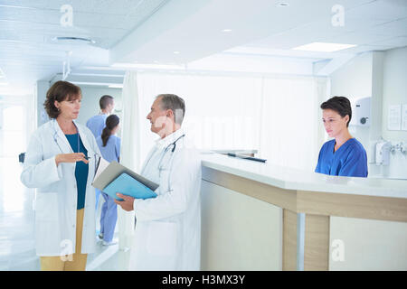 Männliche und weibliche Ärzte medizinische Hinweise am Krankenhaus Krankenschwestern Bahnhof diskutieren Stockfoto
