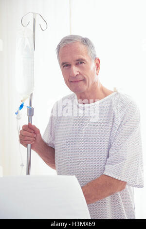 Porträt von älteren männlichen Patienten halten die Infusion im Krankenhaus Stockfoto