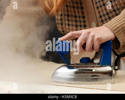 Schuss von jungen weiblichen Designer Dampfbügeln Stoff abgeschnitten Stockfoto