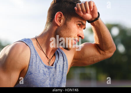 Porträt von ermüdeten Fitness Guy an heißen sonnigen Tag Stockfoto