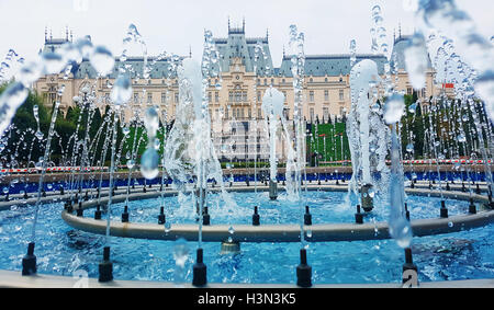 Der Schwall von Wasser von einem Brunnen vor einem schönen Kulturpalast in Stadt Iasi, Rumänien Stockfoto