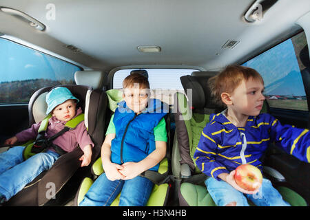 Drei kleine Jungs sitzen im Auto Kindersitze Stockfoto