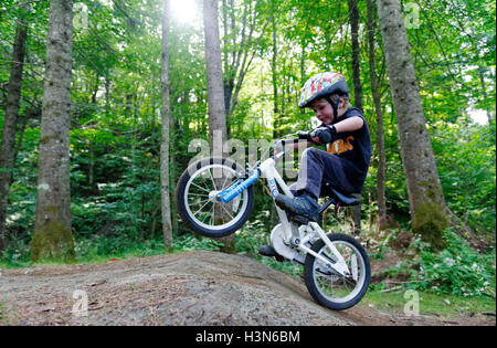 Ein kleiner Junge (4 Jahre alt) Tauchen einen Wheelie auf einem Pumptrack Stockfoto