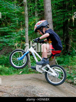 Ein kleiner Junge (4 Jahre alt) Tauchen einen Wheelie auf einem Pumptrack Stockfoto