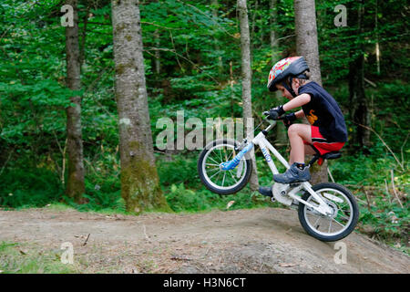 Ein kleiner Junge (4 Jahre alt) Tauchen einen Wheelie auf einem Pumptrack Stockfoto