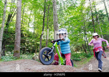 Ein 2 Jahre altes Mädchen auf einem Laufrad mit ihrer Großmutter ängstlich zu jagen. Aufgenommen am Leapfrog Pumptrack am Königreich Trails Vermont Stockfoto