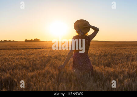 Glückliches Mädchen Sommer Wandern im Feld bei Sonnenuntergang zu genießen. Konzept über Wellness und Urlaub Hintergründe