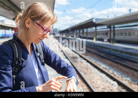 Business-Frau mit Smartwatch am Bahnhof Stockfoto