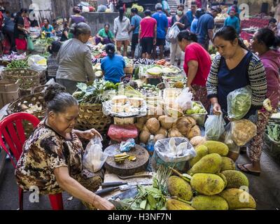 Ubud, Bali, Indonesien. 11. Oktober 2016. Eine Frau kauft Obst von einem Händler in der Morgenmarkt in Ubud. Morgenmarkt in Ubud ist für Produkte und Fleisch und Menschen vor Ort von ca. 04:30 bis etwa 07:30 serviert. Als am Morgen einziehen schreitet die lokalen Anbieter packen und verlassen und Verkäufer, die touristische Kuriositäten. Von ca. 08:30 ist der Markt vor allem einen touristischen Markt Kuriositäten an Touristen zu verkaufen. Ubud ist Balis Kunst- und Kulturzentrum. © Jack Kurtz/ZUMA Draht/Alamy Live-Nachrichten Stockfoto