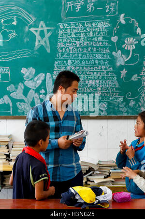 (161011)--Peking, 11. Oktober 2016 (Xinhua)--Foto am 26. September 2016 zeigt ein Student Frage Sang Lei an der Pengdang Primary School in Nujiang der Lisu autonomen Präfektur der südwestlichen chinesischen Provinz Yunnan. Sang Lei, eine College-Diplom studierte in Computer-Ausbildung, wurde als Freiwillige Lehrer der Pengdang Primary School seit 2007. In fast zehn Jahren des Unterrichtens versuchte er sein Bestes, bessere Lernumgebung für seine Schüler. Seit 2006 haben mehr als 500.000 Jugendliche in China wie Sang Lei, zentralen und westlichen China, pädagogischen Unterstützung anzubieten gegangen. Stockfoto