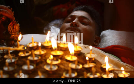 Bhaktapur, Nepal. 11. Oktober 2016. Ein Hindu Anhänger liegt bei brennenden Öllampen auf seinem Körper und bieten Gebete Göttin Durga als Teil eines Rituals während des Dashain Festivals im Bhramayani-Tempel in Bhaktapur, Nepal, 11. Oktober 2016. Hindus in Nepal feiern Sieg über das Böse während Dashain Festivals durch die Verehrung der Göttin Durga sowie andere Götter und Göttinnen. Bildnachweis: Sunil Sharma/Xinhua/Alamy Live-Nachrichten Stockfoto