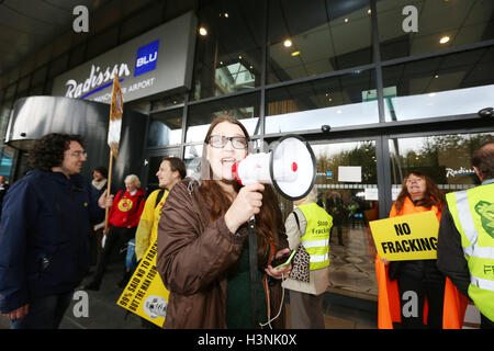 Manchester, UK. 11. Oktober 2016. Anti-Fracking-Kämpferin mit einem Megaphon außerhalb des Radisson BLU, Manchester Flughafen, 11. Oktober 2016 Credit: Barbara Koch/Alamy Live News Stockfoto