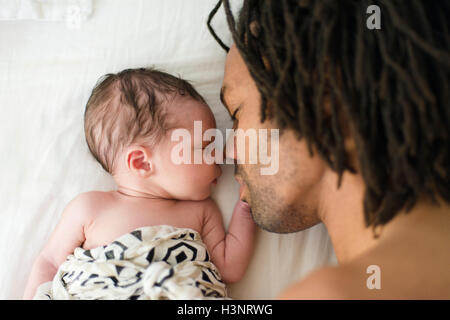 Baby Boy am Bett schlafen neben Vater Stockfoto