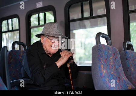 Porträt von senior Mann sitzt im Zug, mit Spazierstock Stockfoto