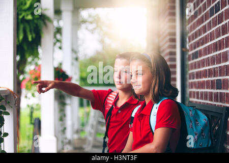 Bruder und Schwester sitzen auf der Bank zeigt, am ersten Tag des neuen Schuljahres Stockfoto