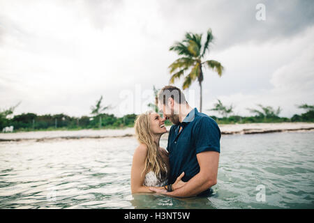 Paar Taille tief im Wasser von Angesicht zu Angesicht lächelnd Stockfoto