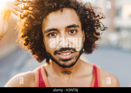 City Portrait der jungen Mann mit Hand in lockiges Haar Stockfoto