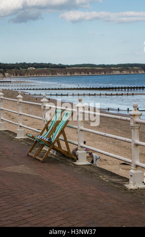 Leere hölzerne Liegestühle mit grünen Streifen am Strand von Bridlington Stockfoto