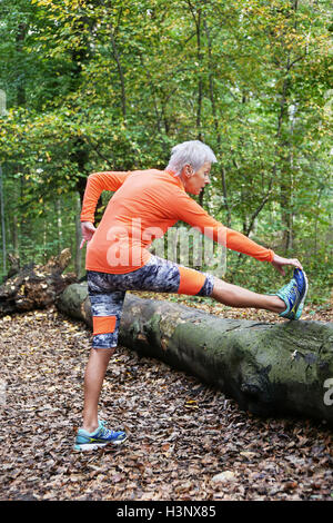 sportliche Reife Frau dehnen Stockfoto