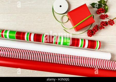 Rote und grüne Weihnachten Geschenkpapier Lieferungen Geschenkpapier, Geschenk-Box, präsentieren, Bänder und natürlichen botanischen Stechpalme Beeren Stockfoto