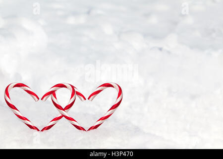 Dual herzförmigen Zuckerstangen im Schnee mit Textfreiraum. Stockfoto