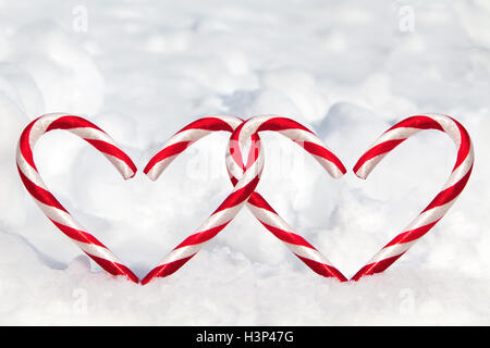 Dual herzförmigen Zuckerstangen im Schnee mit Textfreiraum. Stockfoto