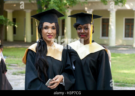 Porträt der glückliche Schüler in Graduierung Kleider Stockfoto