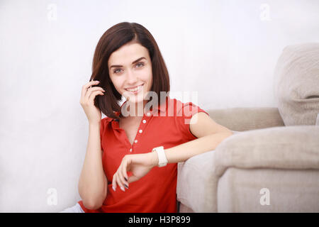 Junge attraktive lächelnde Frau mit ihrem smart-watch Stockfoto