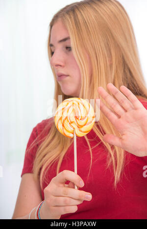 -MODELL VERÖFFENTLICHT. Teenager-Mädchen mit Lolly Pop, Hand hält. Stockfoto