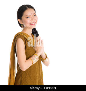 Junge Mischlinge indische chinesische Mädchen in punjabi Tracht Gruß Geste, Stand isoliert auf weißem Hintergrund. Stockfoto