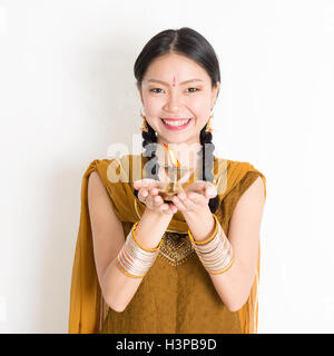 Mischlinge indische chinesische Frauen in traditioneller Tracht Hände halten Diya Öllampe und feiern Diwali oder Deepavali, Offspring Stockfoto
