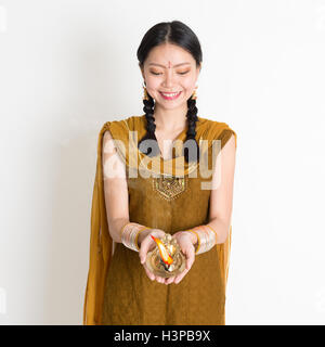 Junge gemischte Rennen indische chinesische Frau in traditioneller Kleidung Händen halten Diya Öllampe und feiern Diwali oder Deepavali, fesi Stockfoto