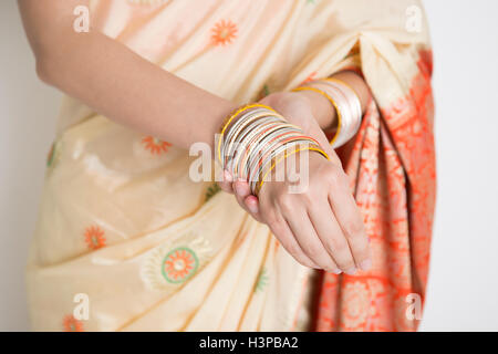 Helle Haut Inderin in traditionellen Sari Kleid tragen Armreifen, stehend auf einfarbigen Hintergrund. Stockfoto