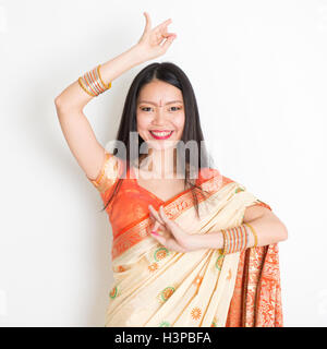 Porträt des jungen Mischlinge indische Chinesin in traditionellen Sari Kleid tanzen auf einfarbigen Hintergrund. Stockfoto