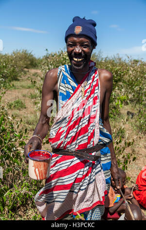 Masai Mara, Kenia, Afrika - 12. Februar 2010 Schamane mit einer Tasse Kuh Blut in traditioneller Kleidung Stockfoto