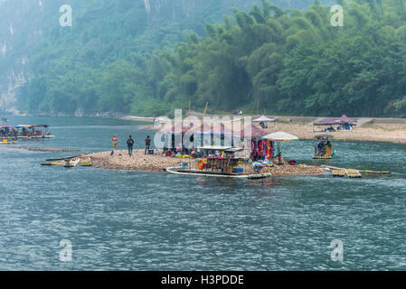 Menschen, Märkte und Bambus Flöße auf einer kleinen Insel auf dem Li-Fluss in Yangshuo, Guangxi, China Stockfoto