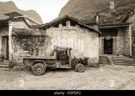 Dorf in China, im grünen, ländlichen asiatischen Bauernhof verbeulten alten Pickup-Truck Stand in der Nähe von Haus aus Stein in Yangshuo, China Stockfoto