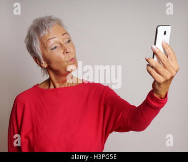 Reife Frau, die ein Smartphone Selfie mit Ente Gesicht Stockfoto