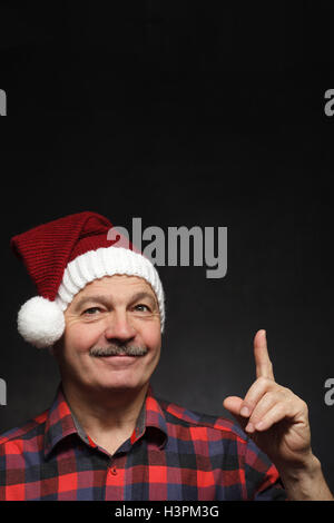 Mann mit einem Schnurrbart in GAP von Weihnachten zeigt Zeigefinger nach oben. Stockfoto