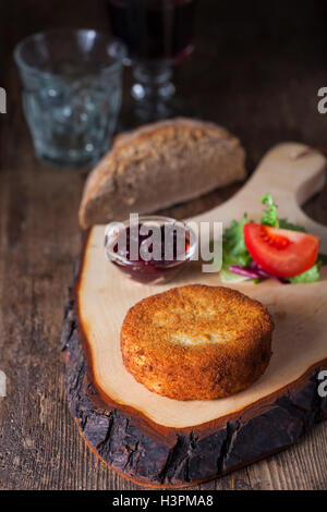 gebackener Camembert auf dunklem Holz Stockfoto