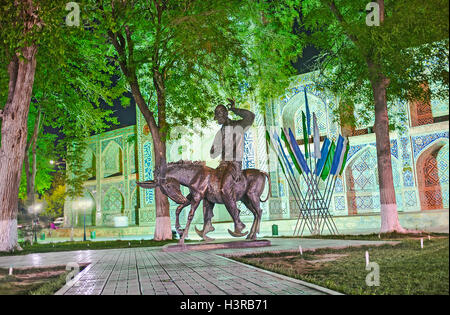 Das Denkmal für Nasreddin Hodja mit Nadir Divan-Beghi Madrasah auf dem Hintergrund in Buchara. Stockfoto