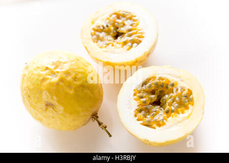 Frischen brasilianischen säuerlichen Passionsfrucht, ganze Früchte und Split Frucht mit saftig innen gefüllt mit zahlreichen Samen Stockfoto