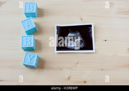 Sonogramm ein kleines Baby auf einem hölzernen Hintergrund. Stockfoto