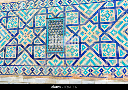 Die Ziegel Rückwand des Tilya Kori Madrasah mit dem Element der stellaren Fliese Muster und Mosaik Bildschirm für das Fenster Stockfoto