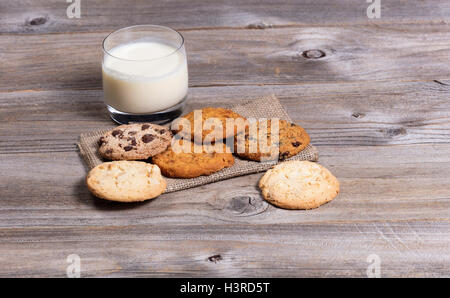 Frontansicht einer Vielzahl von frisch gebackenen Plätzchen auf einer Serviette mit einem Glas Milch. Stockfoto