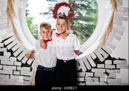 Zwei Brüder stellte im Studiozimmer Hintergrund runden Fenster Stockfoto