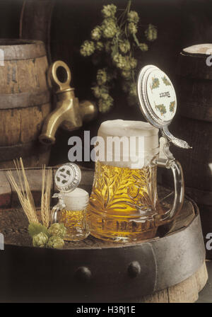 große und kleine Bier-Becher Glas auf Bierfaß Stockfoto