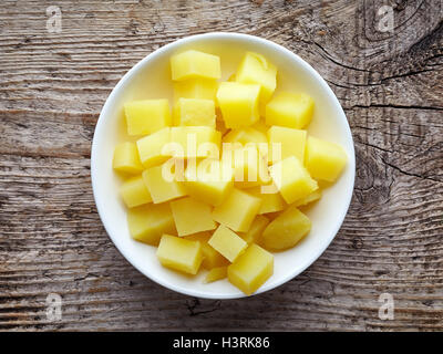 Weiße Schale mit gewürfelten gekochten Kartoffeln auf Holztisch, Ansicht von oben Stockfoto